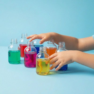 Child playing with colorful sensory bottles, close up hands, bright and clean background, no text, no words, no typography, 8K