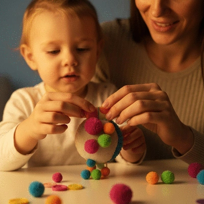Child and parent hands crafting a DIY sensory toy with various materials, warm lighting, no text, no words, no typography, 8K