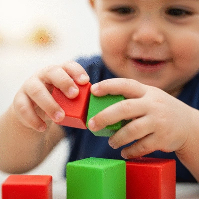 Child playing with building blocks, focus on hands